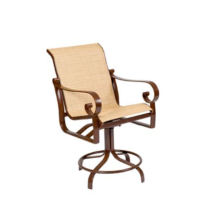 The Belden Sling Swivel Counter Stool features a brown metal frame and beige fabric seat and backrest, with curved armrests and a round base with a leg support ring.
