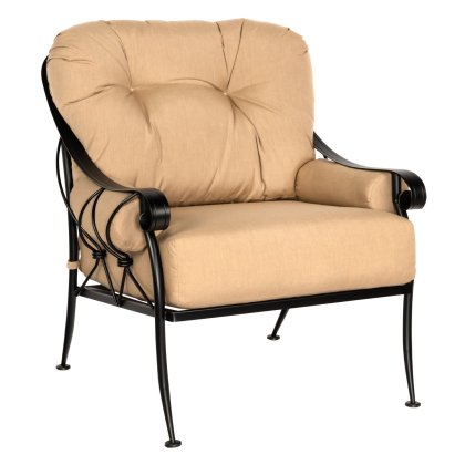 The Derby Lounge Chair features a beige cushioned seat with a black metal frame and decorative armrests. It has a tufted backrest and plush seat, offering comfortable and stylish seating.