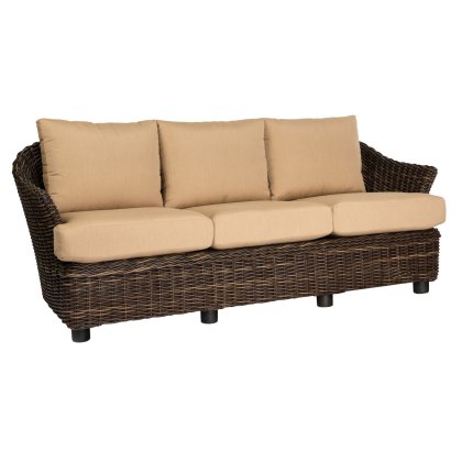 The Sonoma Sofa is a brown wicker piece with beige cushions, featuring a curved back and armrests. It includes three seat and back cushions, supported by black legs, blending natural materials with modern elegance.