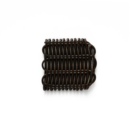 The Marron is a small, rectangular object made of dark metal with a grille-like design of parallel curved rods on the front, forming a woven pattern. It sits against a plain white background.