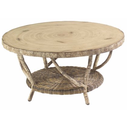 The River Run Coffee Table features a faux birch top with a tree ring pattern, curved legs, and a round wooden design with a natural finish. It includes an extra circular woven shelf underneath for storage.