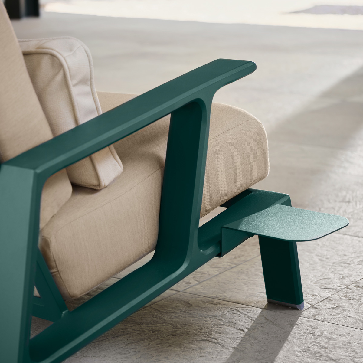 Detail of the Elevation modern Adirondack lounge chair by Woodard with green finish and beige fabric cushions.