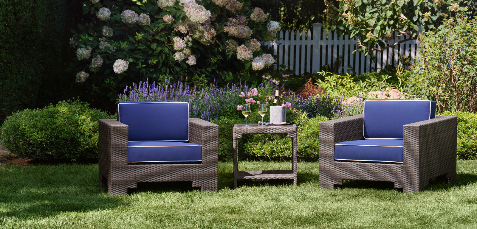 Lorenzo outdoor woven lounge chairs in brown weave with dark blue cushions.
