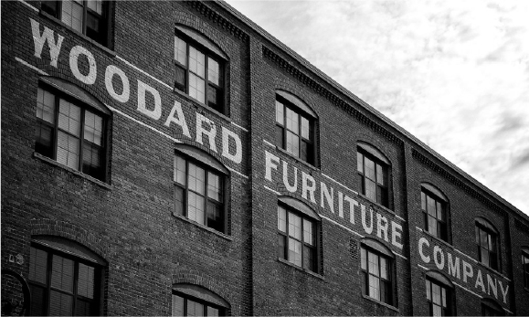 A black and white picture of the old brick Woodard factory.